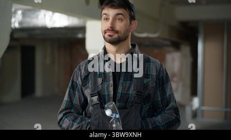 Constructeur ingénieur portant des gants de sécurité construction homme caucasien architecte contremaître maître maître en uniforme commencer le travail de chantier de construction homme homme électricien Banque D'Images