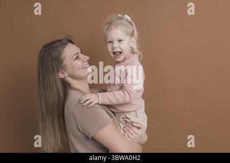 Enfant sourd fille avec implant cochléaire étudiant pour entendre les sons et s'amuser avec sa mère - récupération après chirurgie d'implant cochléaire et réadaptation co Banque D'Images