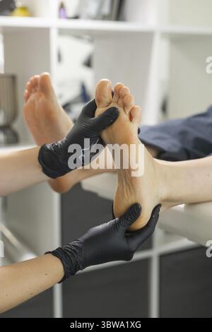 Frau, die Fusspeeling im Pedikuere SPA salon macht. Zuckerpeeling und entspannen Schoenheit Verfahren Banque D'Images