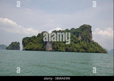 L'une des nombreuses îles calcaires inhabitées recouvertes de jungle dispersées autour de la baie de Phang Nga dans la mer d'Andaman, au sud de la Thaïlande. L'île est loc Banque D'Images