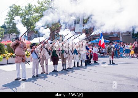 Membres du 5th New York Regiment un groupe de reconstituteurs historiques tire leurs mousquets lors de la célébration du Bastille Day à Piermont, New York. Banque D'Images