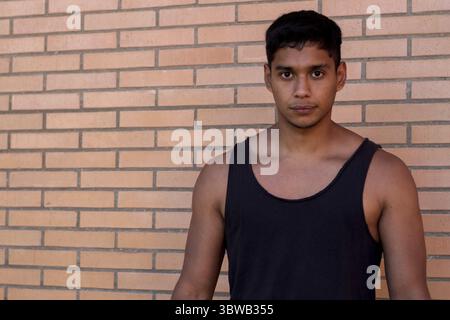 Portrait d'un sportif sérieux d'origine latino portant un débardeur noir dans la rue Banque D'Images