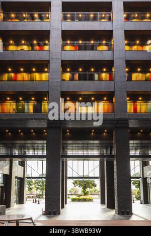 Bâtiment moderne avec balcons colorés et fenêtres éclairées la nuit. Les détails architecturaux et le cadre urbain sont visibles. Offre une ambiance contemporaine, per Banque D'Images