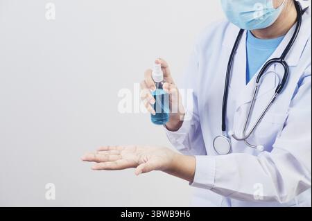Le médecin vaporise du désinfectant pour les mains ou un distributeur de gel pour nettoyer les mains et tuer les virus et les bactéries pour les patients par exemple. Santé médicale personnes et maladie p Banque D'Images