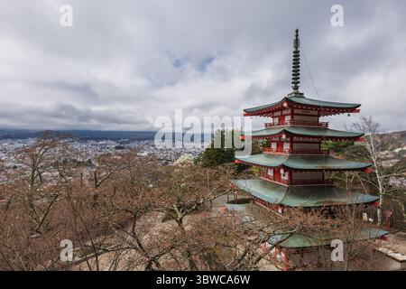 Vue imprenable sur une pagode rouge vibrante surplombant Hakone, au Japon, nichée au milieu des cerisiers en fleurs. Le paysage pittoresque comprend un panorama Banque D'Images