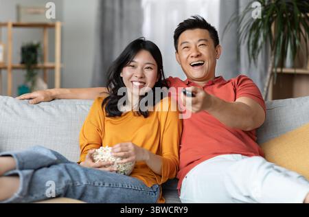 Une famille chinoise détendue regardant la télévision à la maison Banque D'Images