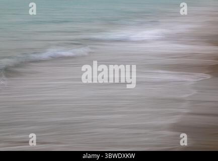 ICM, en mouvement de caméra, les vagues de l'océan créent des lignes texturées blanches le long du sable, l'océan est une couleur aqua, un paysage abstrait, Banque D'Images