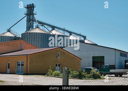 2 juillet 2025 - Rugen-Allemagne : site agricole avec bureau, parking, entrepôt et cinq grands silos à grains avec tour d'ascenseur et système de convoyeur Banque D'Images