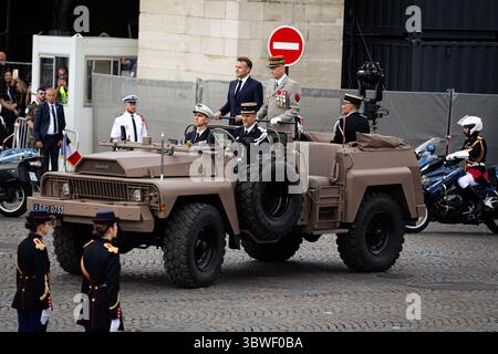 Le président français Emmanuel Macron (à gauche) passe en revue les troupes flanquées par le général Thierry Bukhard (à droite), chef d'état-major français, qui se trouvent dans la voiture de commandement escortée par la Garde républicaine montée française (Garde Républicaine) lors du défilé militaire annuel de la Bastille sur l'avenue des champs-Élysées. Le traditionnel défilé militaire du jour de la Bastille est revenu sur l'avenue des champs-Élysées et la place de la Concorde à Paris, après avoir été déplacé l'année dernière en raison des Jeux Olympiques. L'Indonésie a été l'invité d'honneur de cette année, avec qui la France a signé un accord de partenariat pour prendre pied dans l'Indo-Pa Banque D'Images
