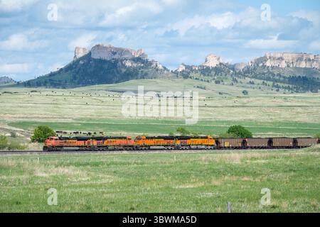Un train de charbon de BNSF serpente dans la vallée pittoresque de Crawford Hill près de Crawford, Nebraska, coupant à travers le paysage luxuriant de Pine Ridge. Banque D'Images