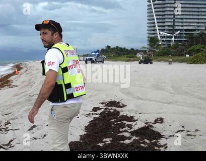 28 juin 2021, Surfside, Floride, États-Unis : DVIR DIMRI, membre de Rescuers WITHOUT Borders, passe devant les barrières sur la plage en direction de l'effondrement du condo Champlain Towers South lundi. (Crédit image : © TNS via ZUMA Wire) Banque D'Images