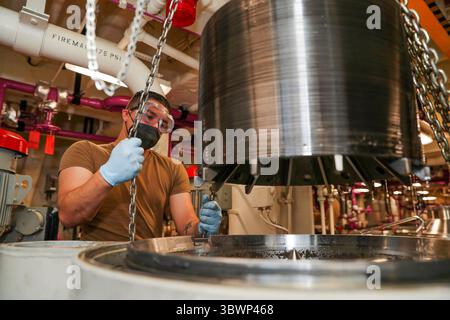 21 juin 2021 - Océan Pacifique - Aviation Boatswains Mate (carburants) Airman Deion Mesa, de Tahlequah, Oklahoma, lève une pile de disques pour nettoyer un purificateur de carburant à bord du navire d'assaut amphibie USS Tripoli (LHA 7), 21 juin 2021. Tripoli mène actuellement des opérations de routine dans la troisième flotte américaine. (Image de crédit : © U.S. Navy/ZUMA Press Wire Service/ZUMAPRESS.com) Banque D'Images