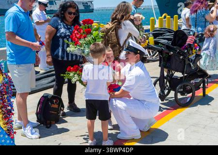 26 juin 2021 - San Diego, Californie, États-Unis - Un marin affecté au navire de combat littoral de la variante de l'indépendance USS Mobile (LCS 26) se réunit avec sa famille sur le quai alors que Mobile arrive à sa base navale de San Diego pour la première fois. La Navy a mis en service Mobile le 22 mai 2021 lors d'une cérémonie à Mobile, Alabama. C'est le 15e LCS porté à San Diego et le 23e LCS à entrer dans la flotte. Les navires de combat littoral sont une plate-forme rapide, agile et axée sur les missions, conçue pour fonctionner dans des environnements proches du littoral, gagnant ainsi contre les menaces côtières du 21e siècle. Les LCS sont capables de prendre en charge la p avant Banque D'Images
