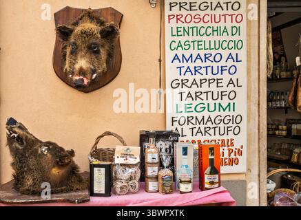 Têtes de sanglier sur le mur du magasin de boucherie, vendant des charcuteries, des saucisses, du salami et des truffes noires, Corso Sertorio dans la ville de Norcia, Ombrie, Italie Banque D'Images