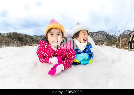 Des enfants japonais jouant dans la neige Banque D'Images
