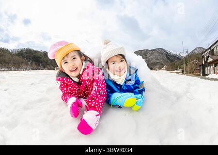 Des enfants japonais jouant dans la neige Banque D'Images