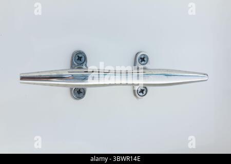 Borne d'amarrage en acier inoxydable sur la coque blanche du yacht. Banque D'Images