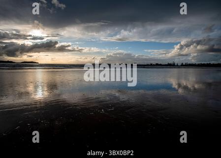 Coucher de soleil sur les vastes plages d’Essaouira avec un ciel bleu, des nuages blancs et des vagues s’écrasant sur le rivage au Maroc Banque D'Images