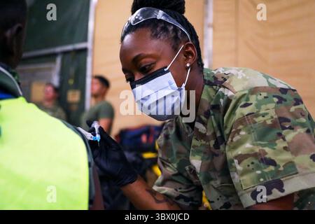 Le 29 juillet 2021 - Djibouti - le médecin de l'US Air Force, le Sgt. Maître Leticia Brésil, l'équipe médicale du 776e Escadron expéditionnaire de la base aérienne (EABS), administre un vaccin COVID-19 à un entrepreneur local à l'aérodrome de Chabelley, le 29 juillet 2021. Les soldats de l’armée américaine affectés à la Force opérationnelle interarmées combinée â€“ Corne de l’Afrique, Camp Lemonnier, Djibouti, se sont rendus à Chabelley pour travailler aux côtés de la 776e équipe médicale de l’EABS dans le cadre d’un effort conjoint prolongé pour vacciner les militaires, les employés djiboutiens et les employés d’autres pays qui travaillent sur les bases militaires américaines à Djibouti. Vaccins à la base nationale locale emp Banque D'Images