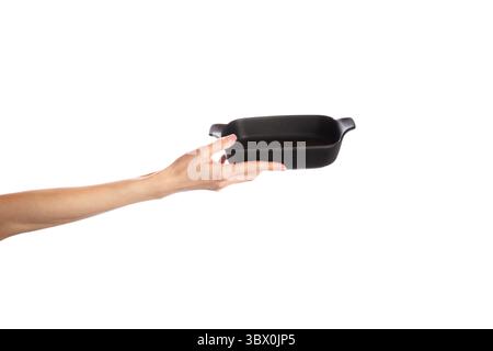 Plat de cuisson noir dans les mains isolé sur fond blanc Banque D'Images