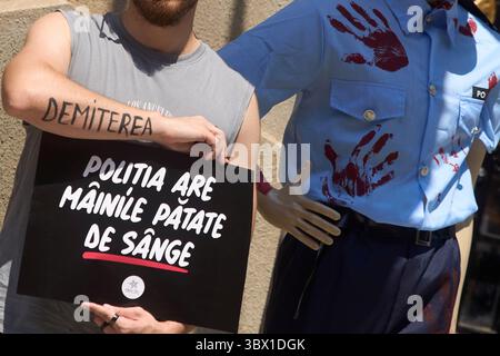 Bucarest, Roumanie. 17 juillet 2025 : manifestation organisée par la communauté déclic devant le siège de la police roumaine (IGPR) à Bucarest, suite au meurtre d'une femme de 22 ans à Lipanesti, dans le comté de Prahova, par son partenaire. Les manifestants ont appelé à la destitution du chef de la police du comté de Prahova, accusant la police d'inaction malgré les plaintes déposées par la victime. Les manifestants ont apporté un mannequin vêtu d'un uniforme de police taché de peinture rouge, symbolisant le sang. Le panneau indique : « les policiers ont les mains tachées de sang ! » Crédit : Lucian Alecu/Alamy Live News Banque D'Images