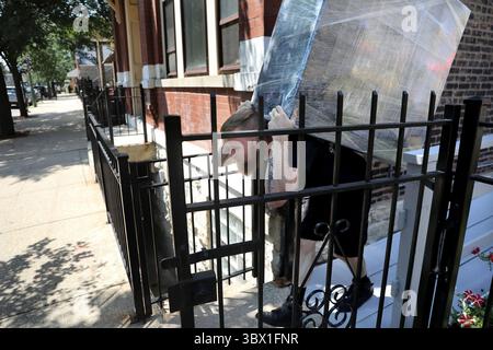12 août 2021 : un déménageur utilise son dos pour transporter une lourde charge pour un client quittant l'Illinois pour New York, dans le bloc 1900 de West Laflin Street à Chicago le lundi 26 juillet 2021. (Crédit image : © Antonio Perez/TNS via ZUMA Press Wire/TNS via ZUMA Press Wire) Banque D'Images