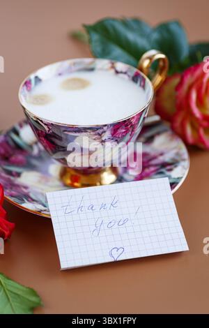 Pause matinale, les roses décorent une carte avec gratitude. Banque D'Images