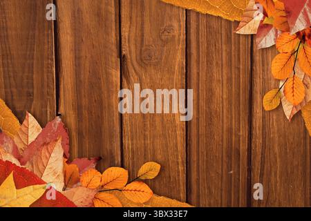 L'amas de feuilles d'automne multicolores repose sur un fond de planche en bois de conception plate. Feuillage d'automne, décor rustique, affichage saisonnier, d'inspiration nature, chaleureux Banque D'Images