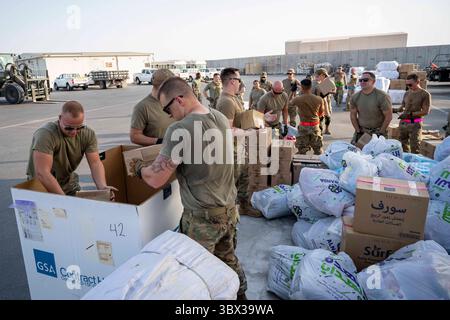 Le 20 août 2021 - Al Dhafra Air base, Abu Dhabi, Émirats arabes Unis - un aviateur de l'US Air Force du 380e escadron de passation de marchés expéditionnaires, du 380e escadron de préparation logistique expéditionnaire et du 380e escadron du génie civil expéditionnaire rassemble des fournitures humanitaires à la base aérienne d'Al Dhafra, Émirats arabes Unis, le 20 août 2021. La 380e équipe ECONS a généré la commande d'un matériel de secours humanitaire qui a été acheté, palettisé et prêt à être envoyé dans les 36 heures pour soutenir les réfugiés afghans qualifiés actuellement évacués par l'armée américaine. (Photo du Sgt. Maître Wolfram Banque D'Images