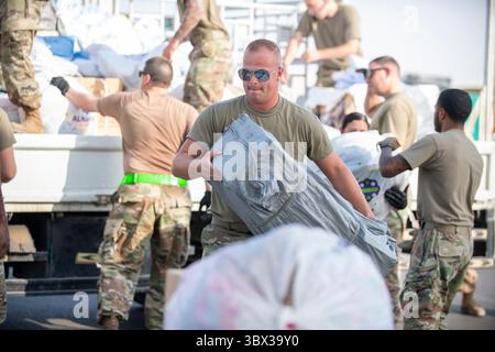 Le 20 août 2021 - Al Dhafra Air base, Abu Dhabi, Émirats arabes Unis - un aviateur de l'US Air Force du 380e escadron de passation de marchés expéditionnaires, du 380e escadron de préparation logistique expéditionnaire et du 380e escadron du génie civil expéditionnaire rassemble des fournitures humanitaires à la base aérienne d'Al Dhafra, Émirats arabes Unis, le 20 août 2021. La 380e équipe ECONS a généré la commande d'un matériel de secours humanitaire qui a été acheté, palettisé et prêt à être envoyé dans les 36 heures pour soutenir les réfugiés afghans qualifiés actuellement évacués par l'armée américaine. (Photo du Sgt. Maître Wolfram Banque D'Images