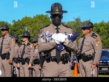23 août 2021, Miami, Floride, États-Unis : le capitaine James Edwards de la patrouille routière de Floride porte le drapeau américain lors des funérailles du soldat Lazaro R. Febles de la patrouille routière de Floride au cimetière de Woodlawn Park dans le sud-ouest de Miami-Dade le vendredi 20 août 2021. Febles a servi plus de 11 ans avec la Florida Highway Patrol dans la Troop E Miami, il est mort des complications de COVID-19. (Crédit image : © Al Diaz/TNS via ZUMA Press Wire/TNS via ZUMA Press Wire) Banque D'Images