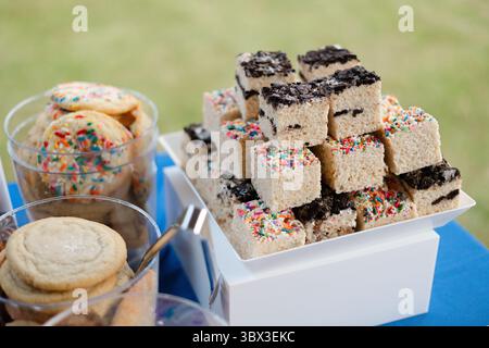 Lors d'un événement, les clients apprécieront une variété de friandises sucrées, dont des carrés de riz croustillants recouverts de saupoudrées et de biscuits. Banque D'Images