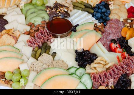 Une délicieuse tartinade de viandes, fromages, fruits et noix magnifiquement arrangés pour une réunion sociale décontractée Banque D'Images