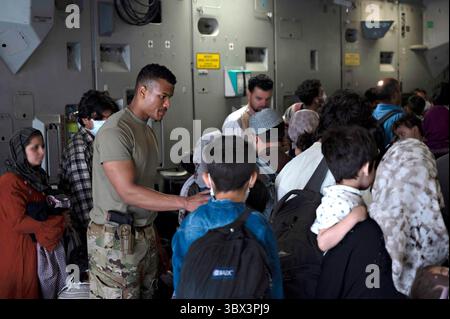 STYLELOCATIONA un aviateur de l'armée de l'air américaine aide les réfugiés afghans à monter à bord d'un avion C-17 Globemaster III de l'armée de l'air lors de l'évacuation de l'aéroport international Hamid Karzai lors de l'opération Allies refuge le 24 août 2021 à Kaboul, en Afghanistan. (Crédit image : © Sra Taylor Crul/U.S. Air/Planet Pix via ZUMA Press Wire) Banque D'Images