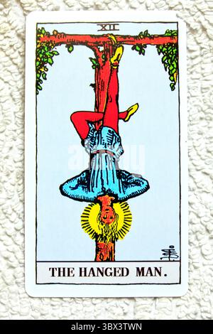 L'homme pendu - numéro 12 - studio de cartes Tarot individuel mis en place sur fond texturé. Prise en juillet 2025 Banque D'Images