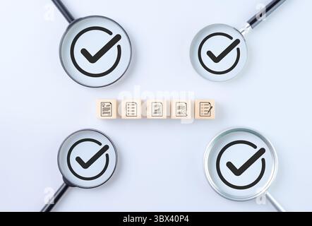 Assurance qualité et concept de certification standard. Blocs en bois avec revue de document et icône de liste de contrôle. loupe avec des coches Banque D'Images