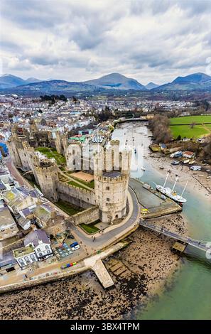 Une vue aérienne devant le château et le long de la rivière Seiont vers Snowdonia à Caernarfon, pays de Galles au printemps Banque D'Images