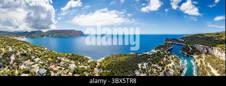 Vue aérienne panoramique de Cassis, ses superbes calanques et la mer Méditerranée scintillante, avec voiliers et petits bateaux qui glissent paisiblement à la gorge Banque D'Images