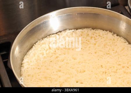 Une casserole de riz blanc cuit sur une cuisinière Banque D'Images