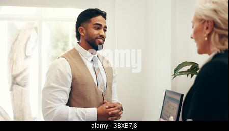 Hôtel, concierge et homme avec client à la réception pour réservation, réservation de chambre et check-in. Hospitalité, réceptionniste et personne avec femme Banque D'Images