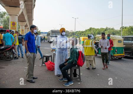 10 octobre 2021, New Delhi, Inde : un travailleur de la santé portant un équipement de protection individuelle (EPI) prélève un échantillon d'écouvillon d'un homme pour un test COVID-19 lors d'un essai aléatoire pour les voyageurs près de la frontière de Delhi Uttar Pradesh au terminal de bus Anand Vihar. Le gouvernement de Delhi prend des mesures de précaution contre le COVID-19 pendant que les gens voyagent pendant la saison des festivals. (Crédit image : © Pradeep Gaur/SOPA images via ZUMA Press Wire) Banque D'Images