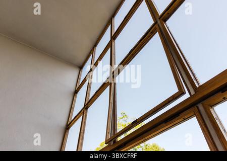 Cadres de fenêtres en bois avec des vitres transparentes offrant une vue sur un paysage extérieur ensoleillé Banque D'Images