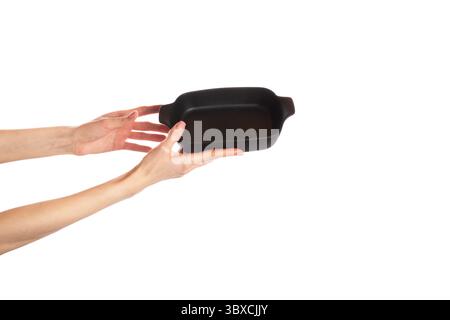 Plat de cuisson noir dans les mains isolé sur fond blanc Banque D'Images