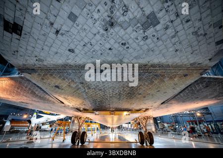 CHANTILLY, Virginie — des tuiles de bouclier thermique, brûlées par la rentrée atmosphérique, sont visibles sous la navette spatiale Discovery comme exposé dans le hangar spatial James S. McDonnell au Steven F. Udvar-Hazy Center du Smithsonian National Air and Space Museum. Discovery a effectué 39 missions de 1984 à 2011, plus que tout autre engin spatial de l'histoire, accumulant 365 jours dans l'espace et parcourant 149 millions de miles (240 millions de kilomètres). L'orbiteur a servi de véhicule de retour au vol de la NASA après la catastrophe de Challenger en 1986 et celle de Columbia en 2003. Découverte déployée Banque D'Images