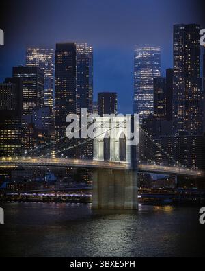 Pont de Brooklyn avec horizon de New York la nuit - East River coule dans la soirée avec les lumières des gratte-ciels de Lower Manhattan reflétées au crépuscule Banque D'Images