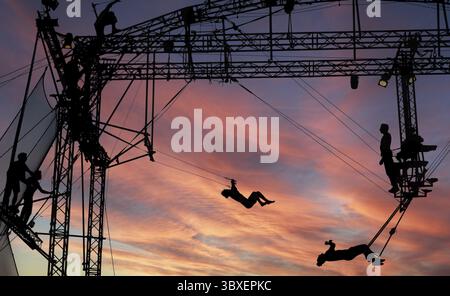 Sibiu City, Roumanie - 28 juin 2022 silhouettes d'artistes de trapèze acrobates de CirkVOST, sur l'échafaudage métallique au Théâtre International Festiv Banque D'Images
