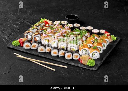 Set pour la grande entreprise avec makizushi, Philadelphie et petits pains californiens avec saumon frais et torché, masago, thon et crevettes garnis de wakame et Banque D'Images