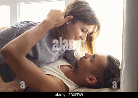 Portrait d'un couple multiracial, petit ami et petite amie face à face, se trouvent près de la fenêtre Banque D'Images