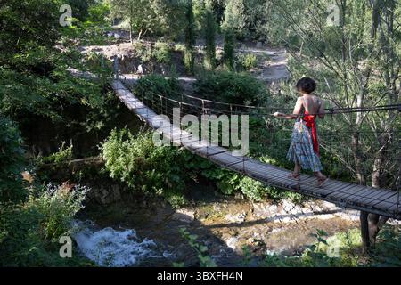 Tbilissi, Géorgie. 13 juillet 2025. Un touriste traverse un pont de corde en bois à l'intérieur du jardin botanique national de Géorgie dans la gorge de Tsavkisis-Tskali. (Crédit image : © John Wreford/SOPA images via ZUMA Press Wire) USAGE ÉDITORIAL SEULEMENT ! Non destiné à UN USAGE commercial ! Banque D'Images