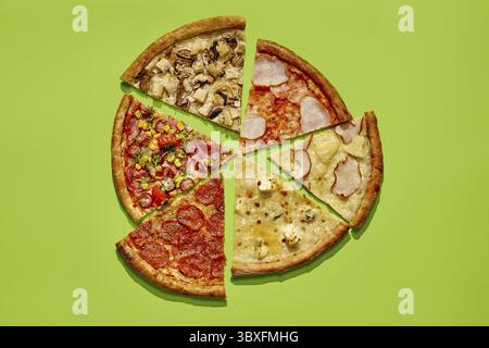 Variété de tranches de pizza avec différentes garnitures créant une pizza complète sur un fond vert vibrant Banque D'Images